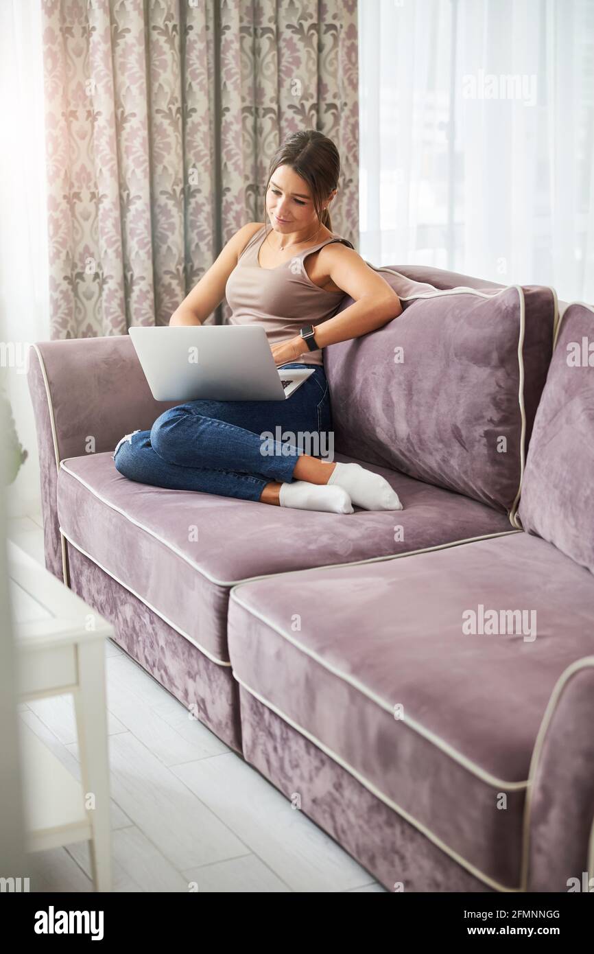 Pleased young woman staring at screen of computer Stock Photo