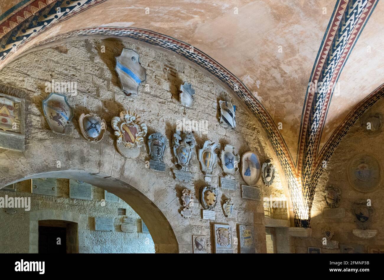 Volterra, Italy,The entrance hall of the Dei Priori palaca, with coats of arms of local noble families Stock Photo