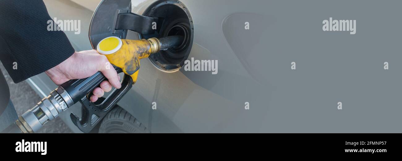 Close up of man pumping fuel in car at gas station. Pumping gas web banner. Stock Photo