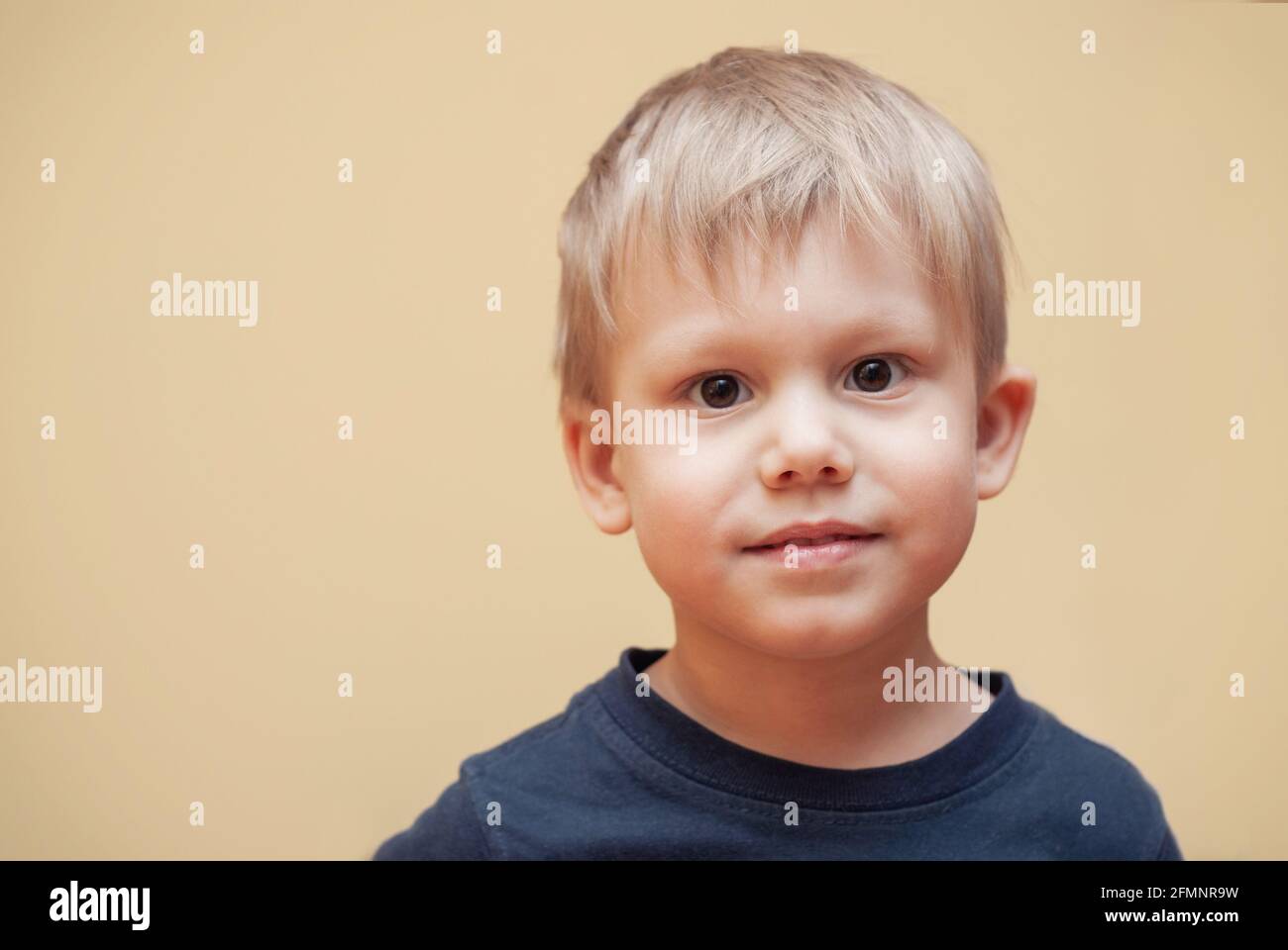 Portrait of adorable little boy with brown eyes in dark outfit posing