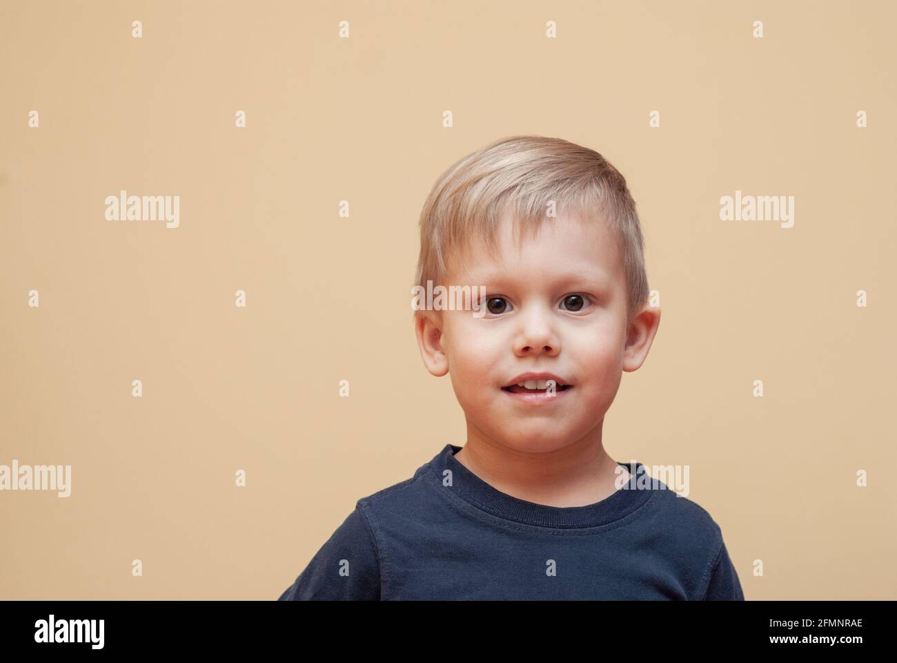 Portrait of adorable little boy with brown eyes in dark outfit posing
