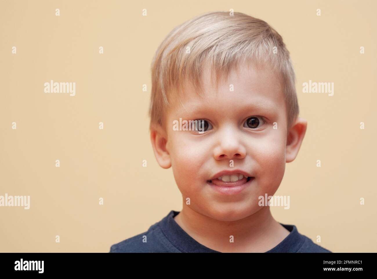 Portrait of adorable little boy with brown eyes in dark outfit posing