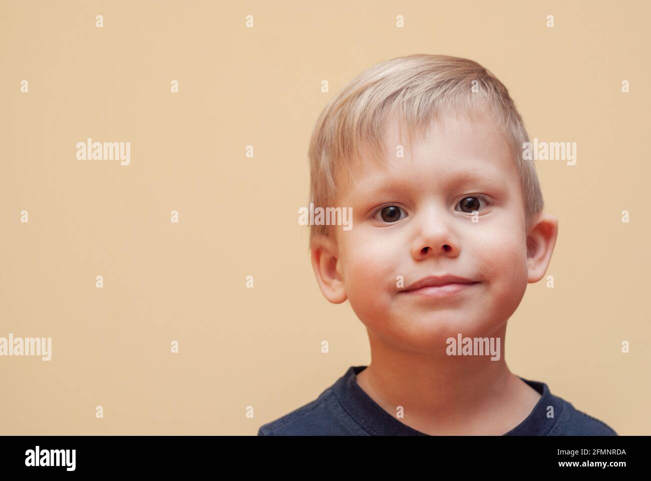 Portrait of adorable little boy with brown eyes in dark outfit posing