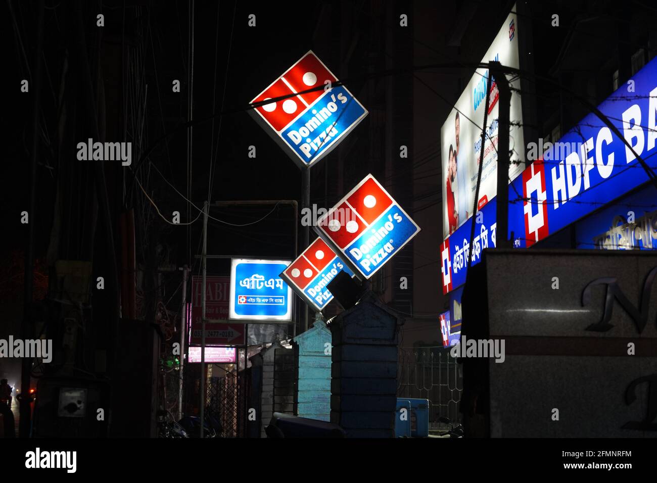 February 2021, Kolkata, India, Neon signs glow boards of Domino' pizza and HDFC Bank during lockdown pandemic at night. Stock Photo