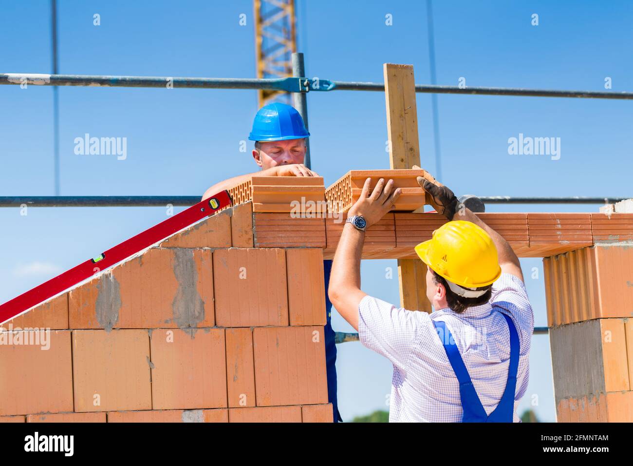 Two Bricklayer or builder or worker build or bricklaying or laying a ...