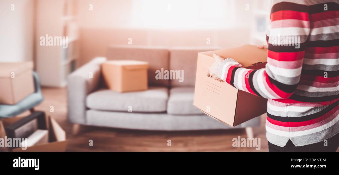 Woman carrying cardboard box in her hands Stock Photo