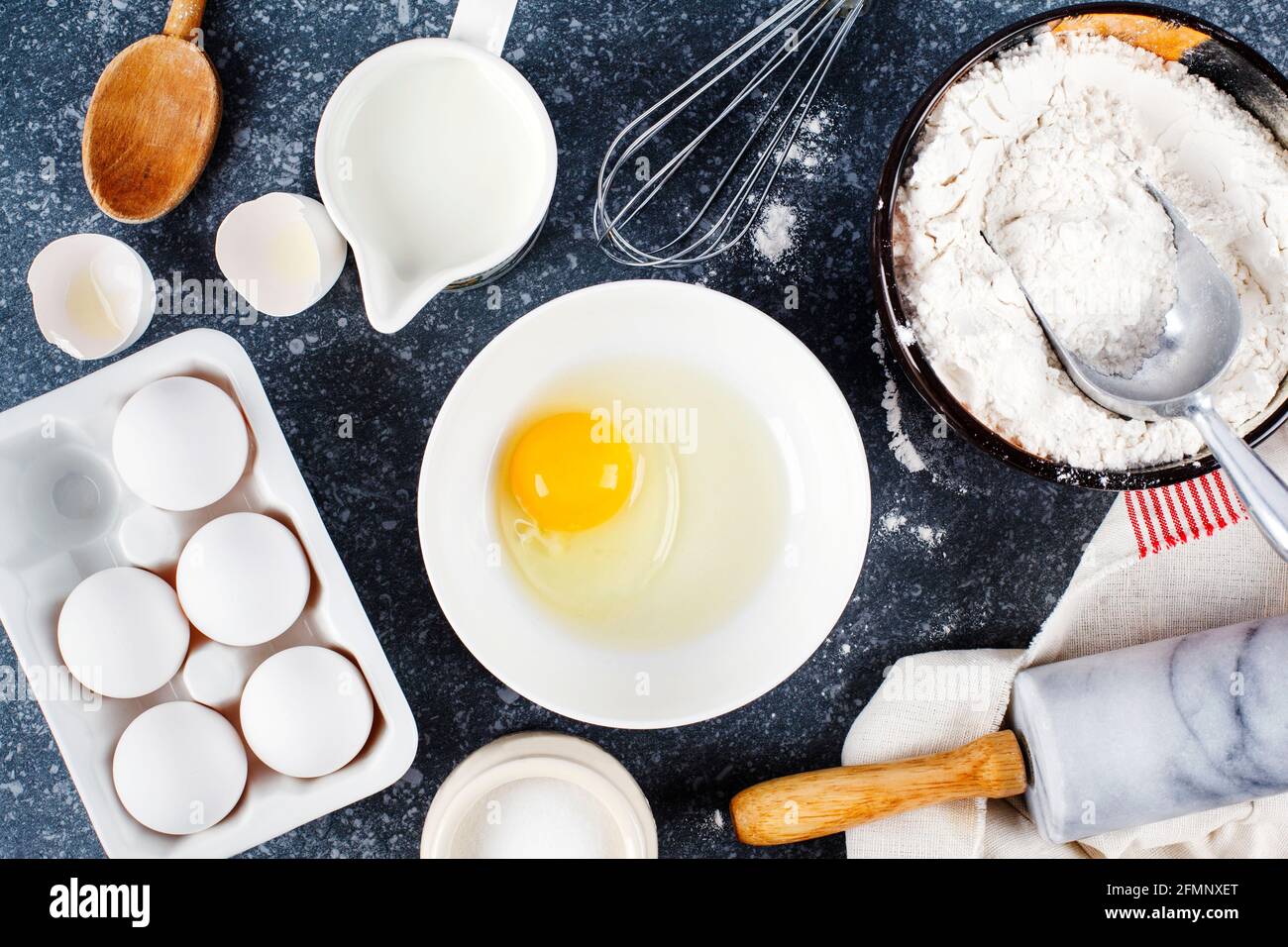 Baking concept. Marble rolling pin with flour and eggs on a dark background Baking background Stock Photo