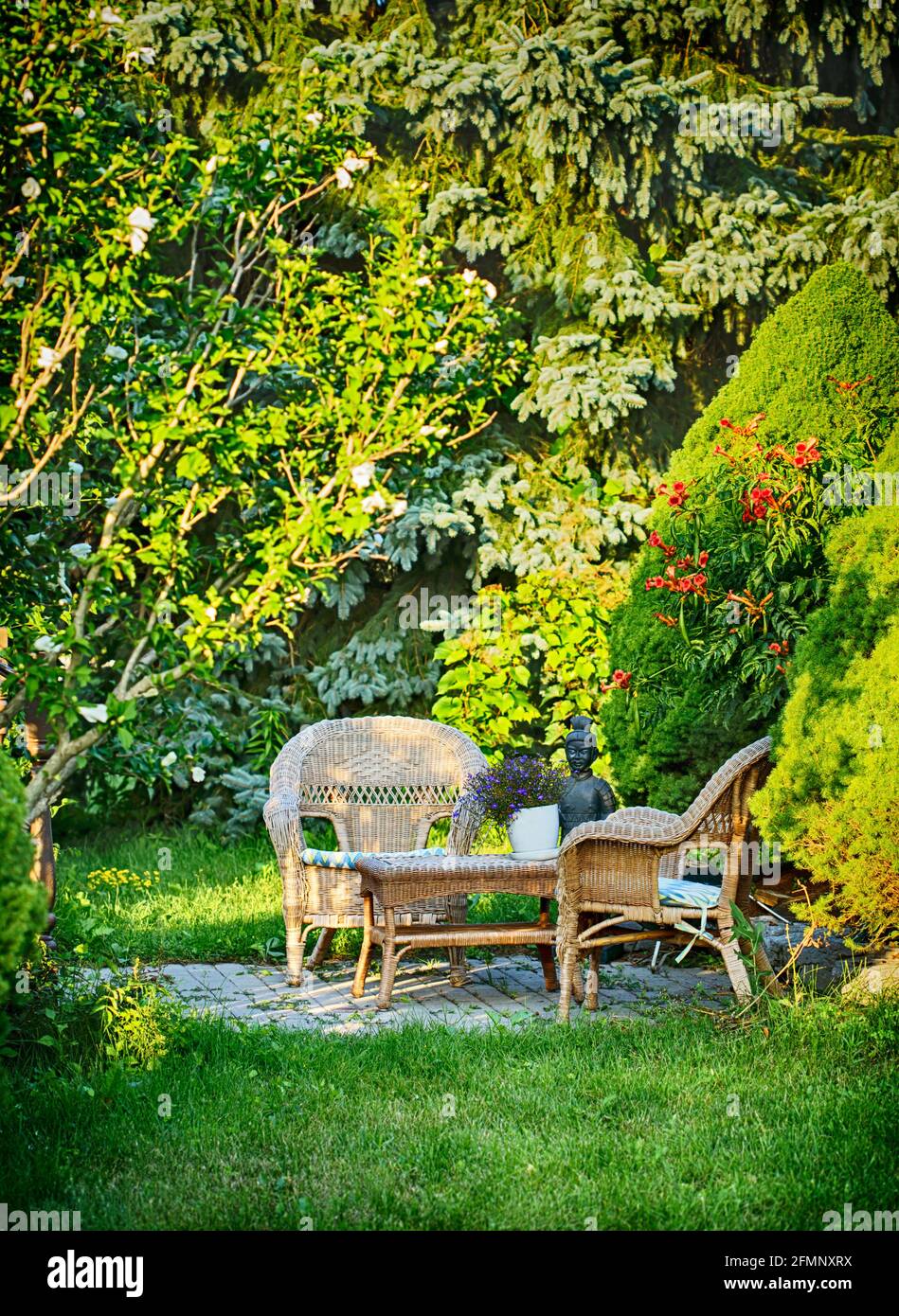 Wicker chairs and a table in the summer garden Stock Photo
