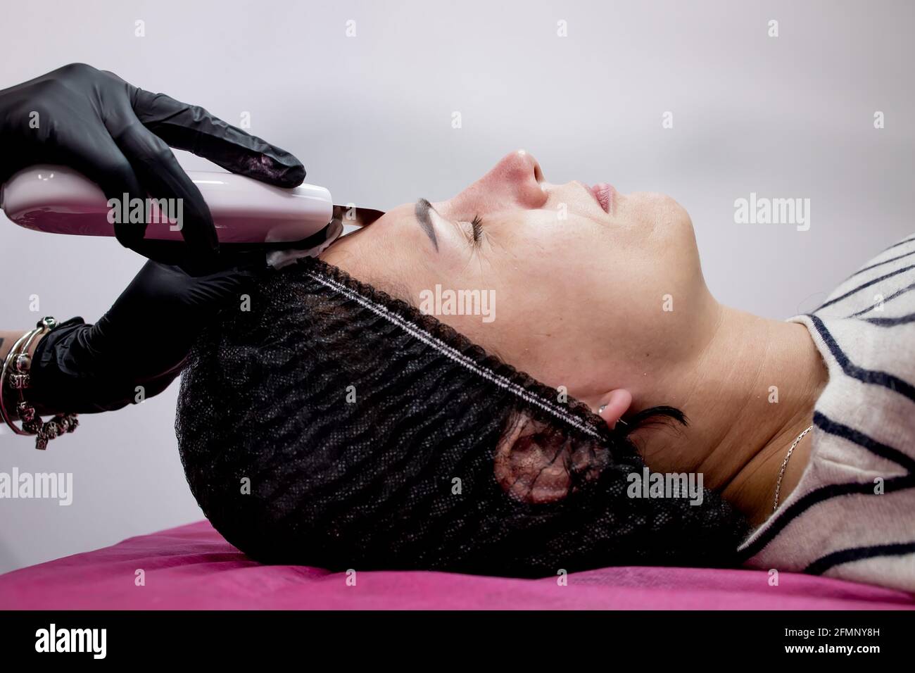 Cosmetologist,beautician making facial treatment with ultrasonic