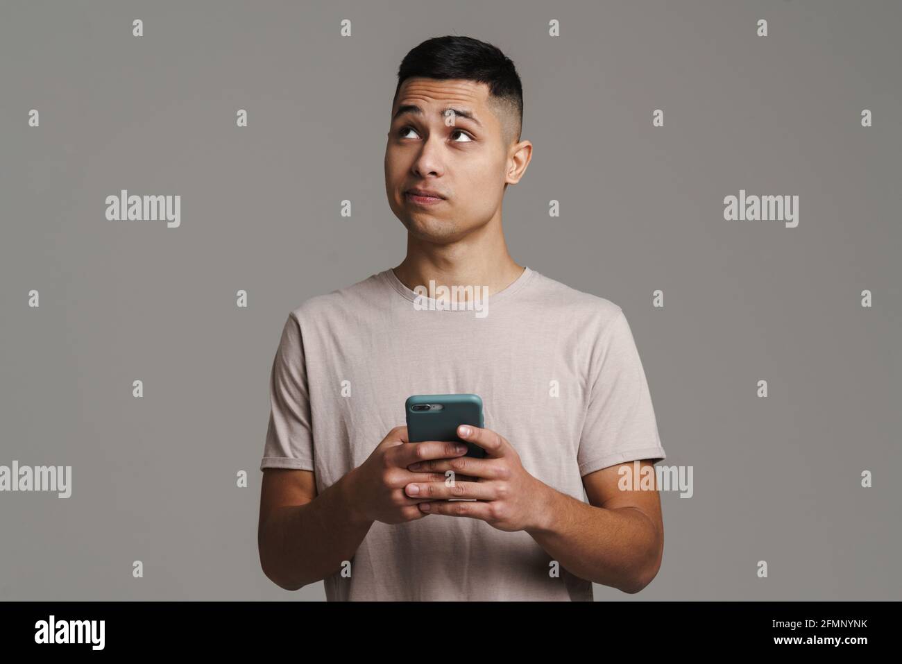 Brooding Look Man Brunette young brooding man looking upward while using mobile phone ...