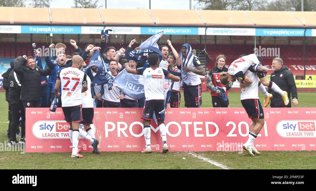 The Bolton players and staff celebrate promotion after their  win against Crawley in the Sky Bet League Two match between Crawley Town and Bolton Wanderers at the People's Pension Stadium  , Crawley ,  UK - 8th May 2021 -  EDITORIAL USE ONLY No use with unauthorised audio, video, data, fixture lists, club/league logos or “live” services. Online in-match use limited to 120 images, no video emulation. No use in betting, games or single club/league/player publications Stock Photo
