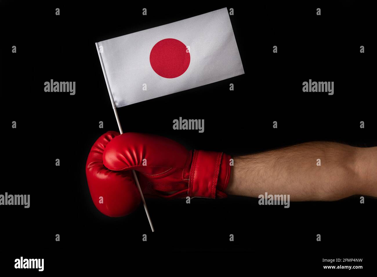 Boxer hand holds flag of Japan. Boxing glove with the Japanese flag