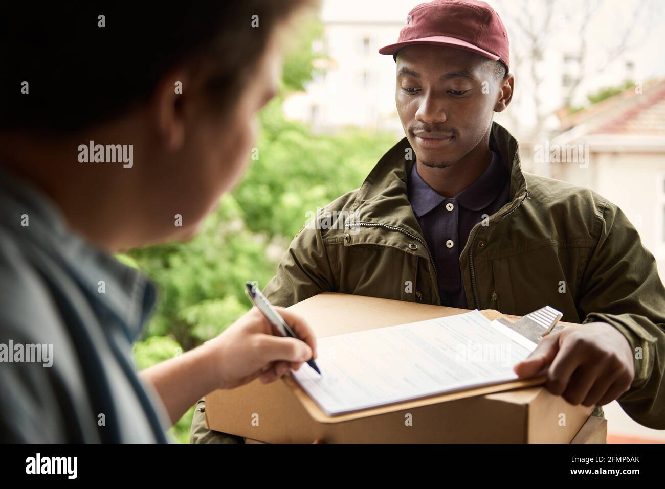 African courier having a customer signer for a delivery Stock Photo