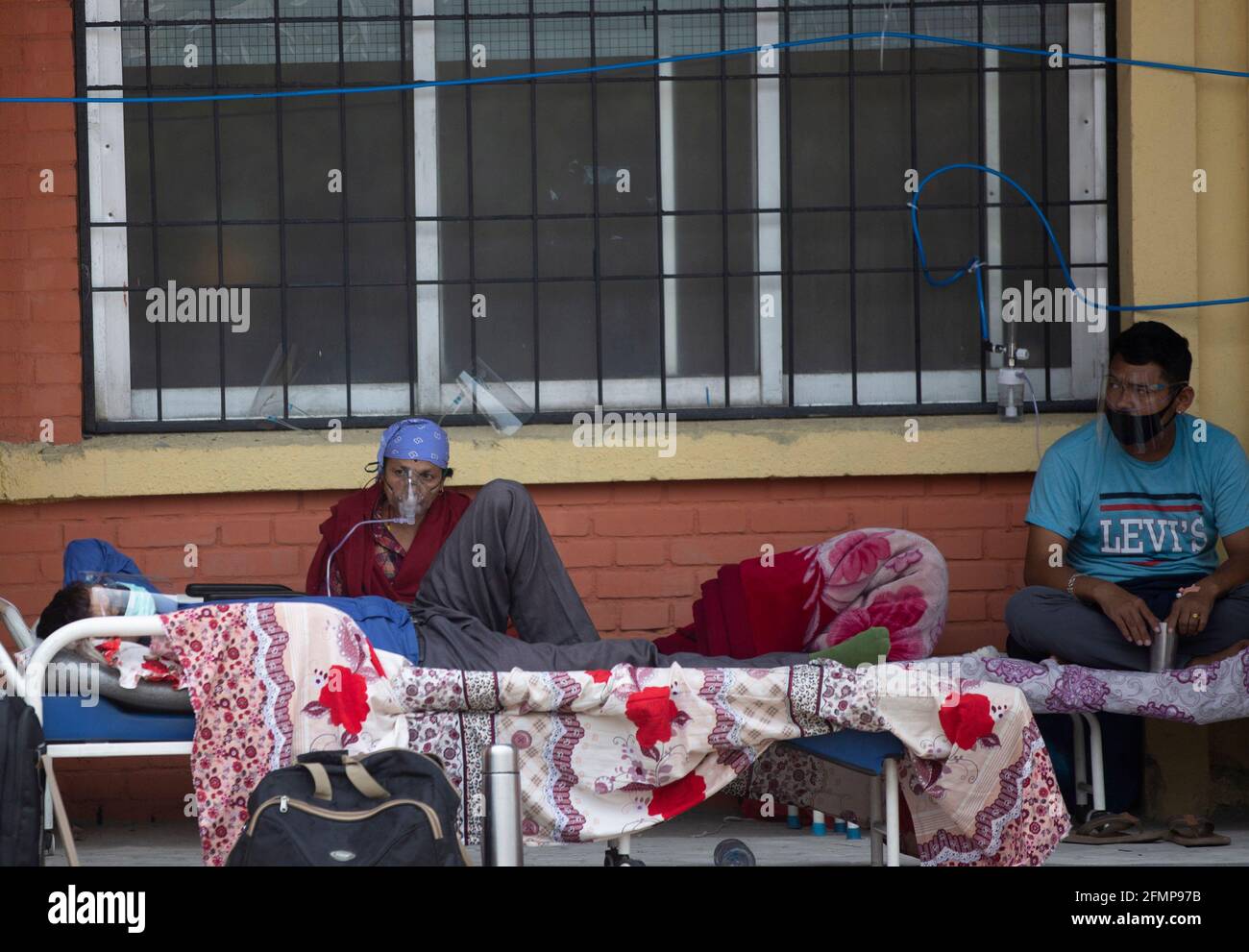 Kathmandu, Nepal. 11th May, 2021. Patients receive oxygen as they wait outside the passage of a hospital due to a lack of free beds inside the hospital for coronavirus disease (COVID-19) patients, as the second major coronavirus wave surges in Kathmandu, Nepal, May 11, 2021. Credit: Dipen Shrestha/ZUMA Wire/Alamy Live News Stock Photo
