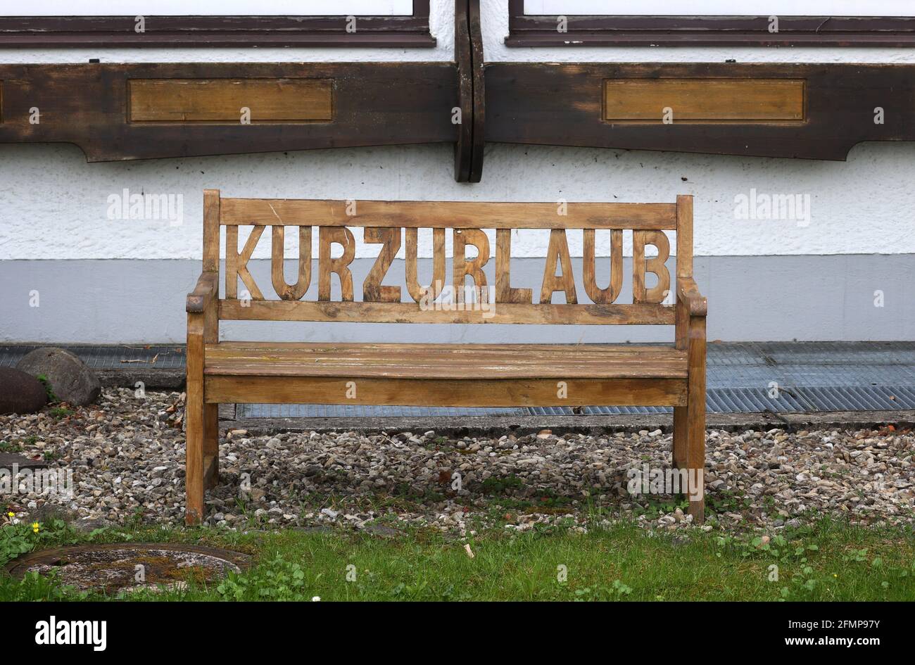 Oberstdorf, Germany. 11th May, 2021. The word 'Kurzurlaub' (short holiday) is carved into the back of a bench in front of a hotel. Whitsun holiday in Bavaria? Yes, but only with stable low incidences. For many tourism businesses, this means: hope and fear. The hotel and restaurant association demands more planning security from the state government. Credit: Karl-Josef Hildenbrand/dpa/Alamy Live News Stock Photo
