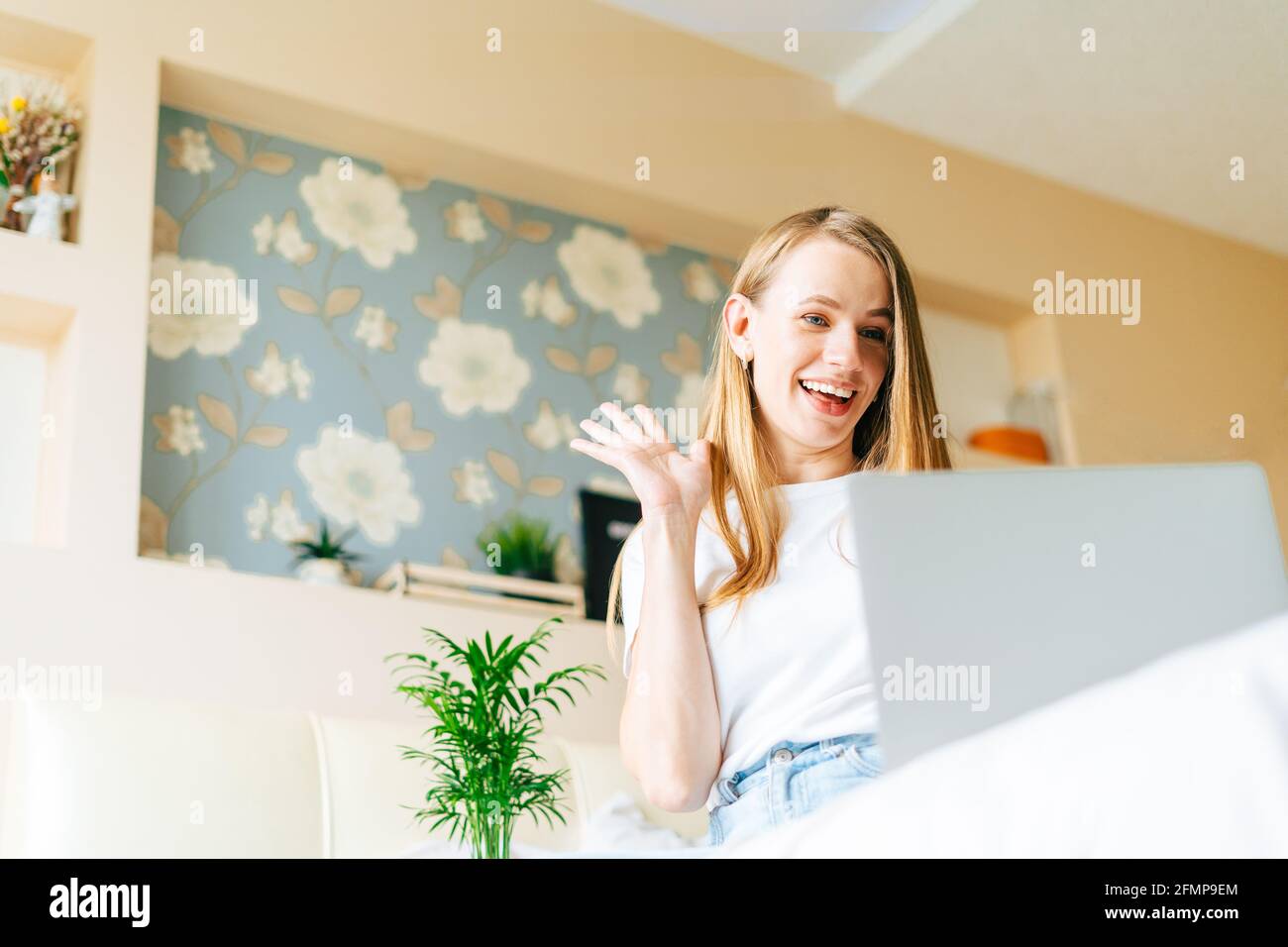 Blonde woman working at home with laptop Stock Photo