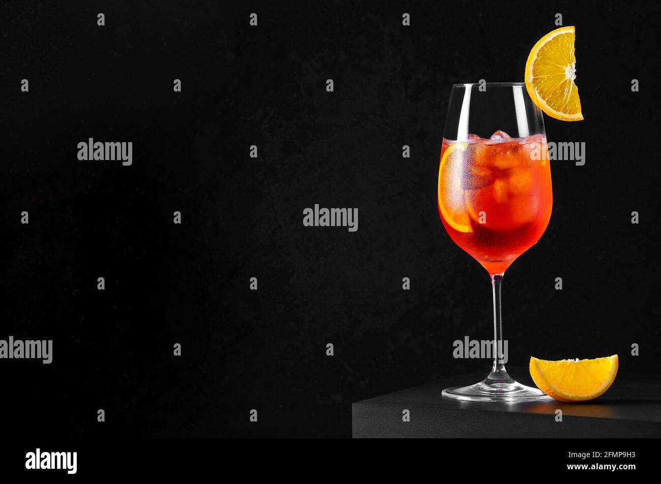 Aperol Spritz Cocktail in wine glass with ice and orange slice on dark ...