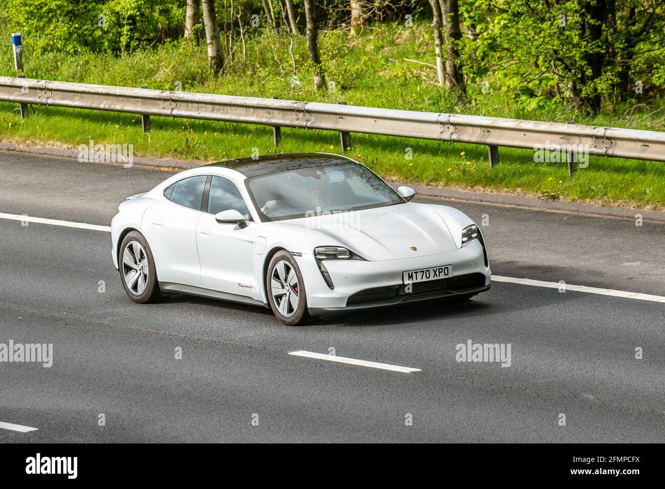 2020 white Porsche Taycan 4s 93KWH sports car; Vehicular traffic, moving vehicles, cars, vehicle driving on UK roads, motors, motoring on the M6 motorway highway UK road network. Stock Photo