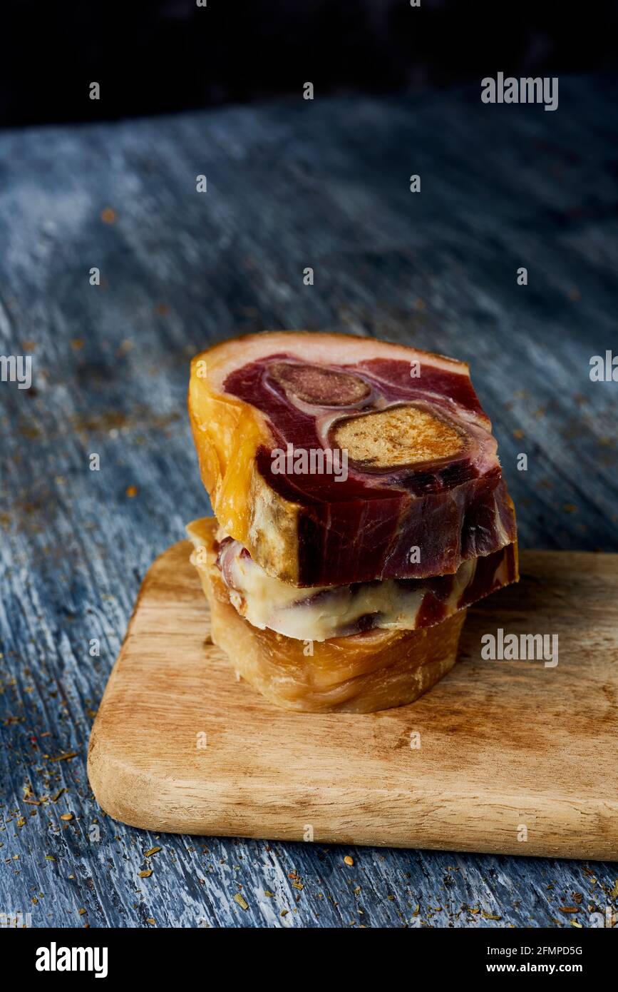 closeup of some cuts of codillo de jamon, spanish ham hock, on a gray rustic wooden table Stock Photo