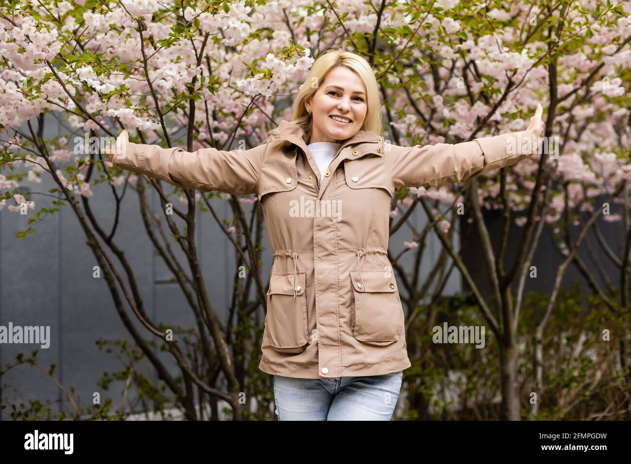 Pretty woman in cherry blossom garden, spring time Stock Photo - Alamy