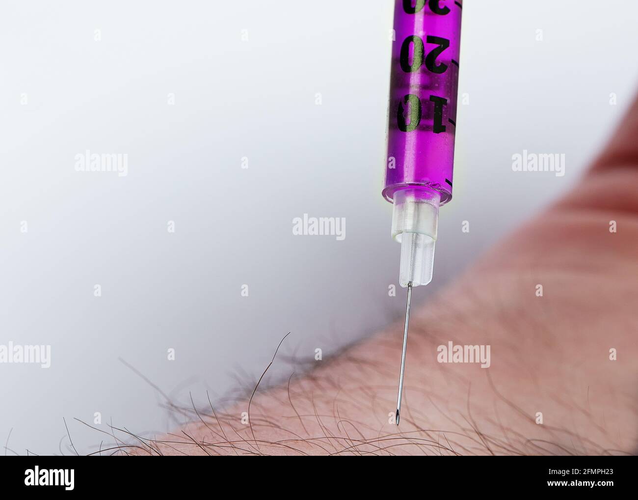 Injection needle going into skin Stock Photo Alamy