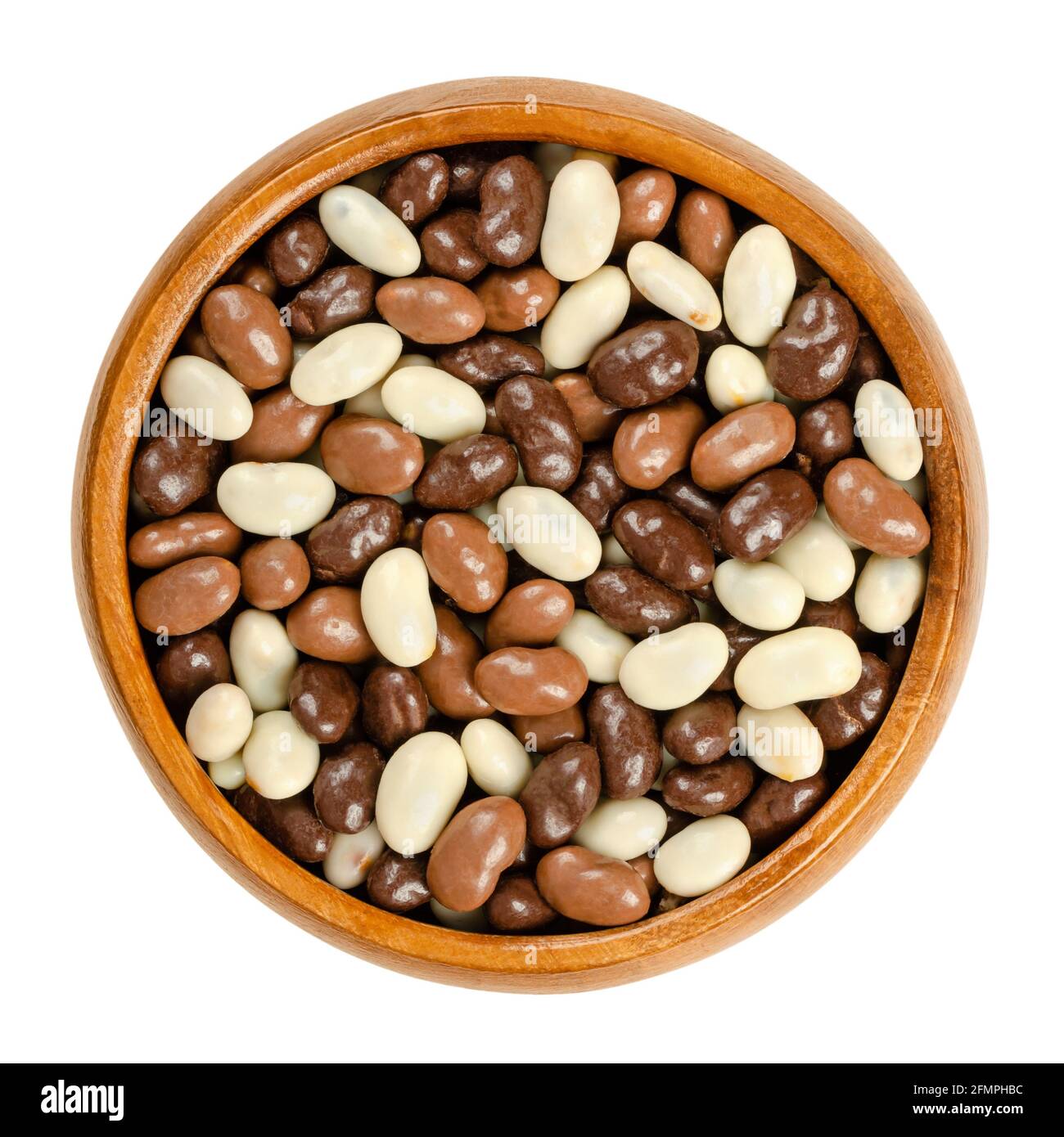 Roasted soybeans, coated with chocolate, in a wooden bowl. Snack of crispy roasted soybeans, covered with dark, milk and white chocolate. Close-up. Stock Photo