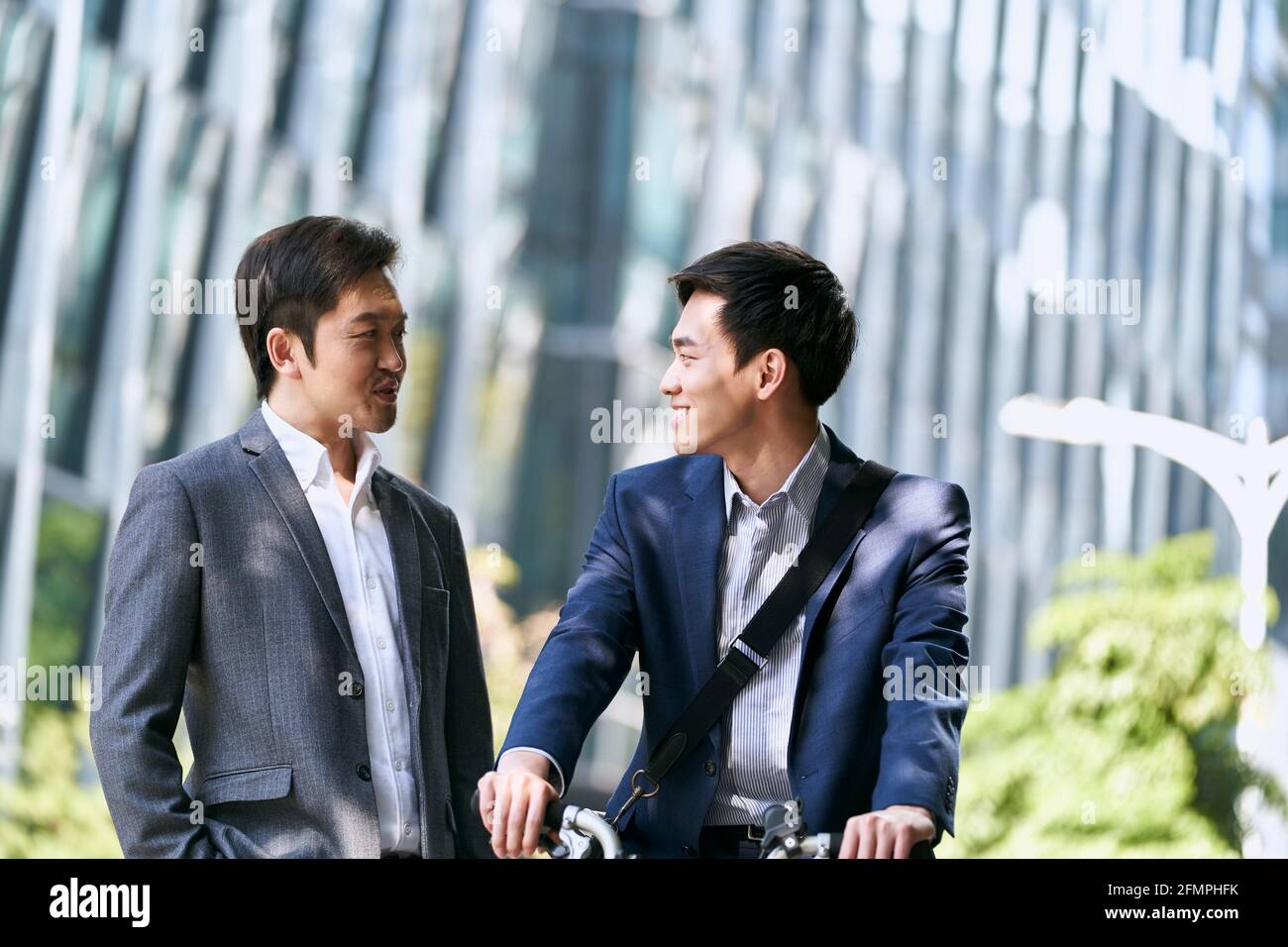 two asian business associates having a conversation in downtown of modern city Stock Photo