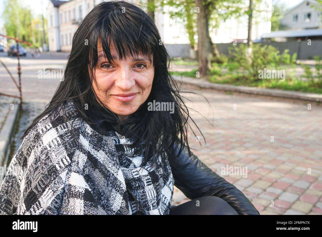 portrait of a woman. Happy smiling Caucasian woman with black medium hair. Copy space concept.  Ageing and wrinkles. Getting old. Happy retirement Stock Photo