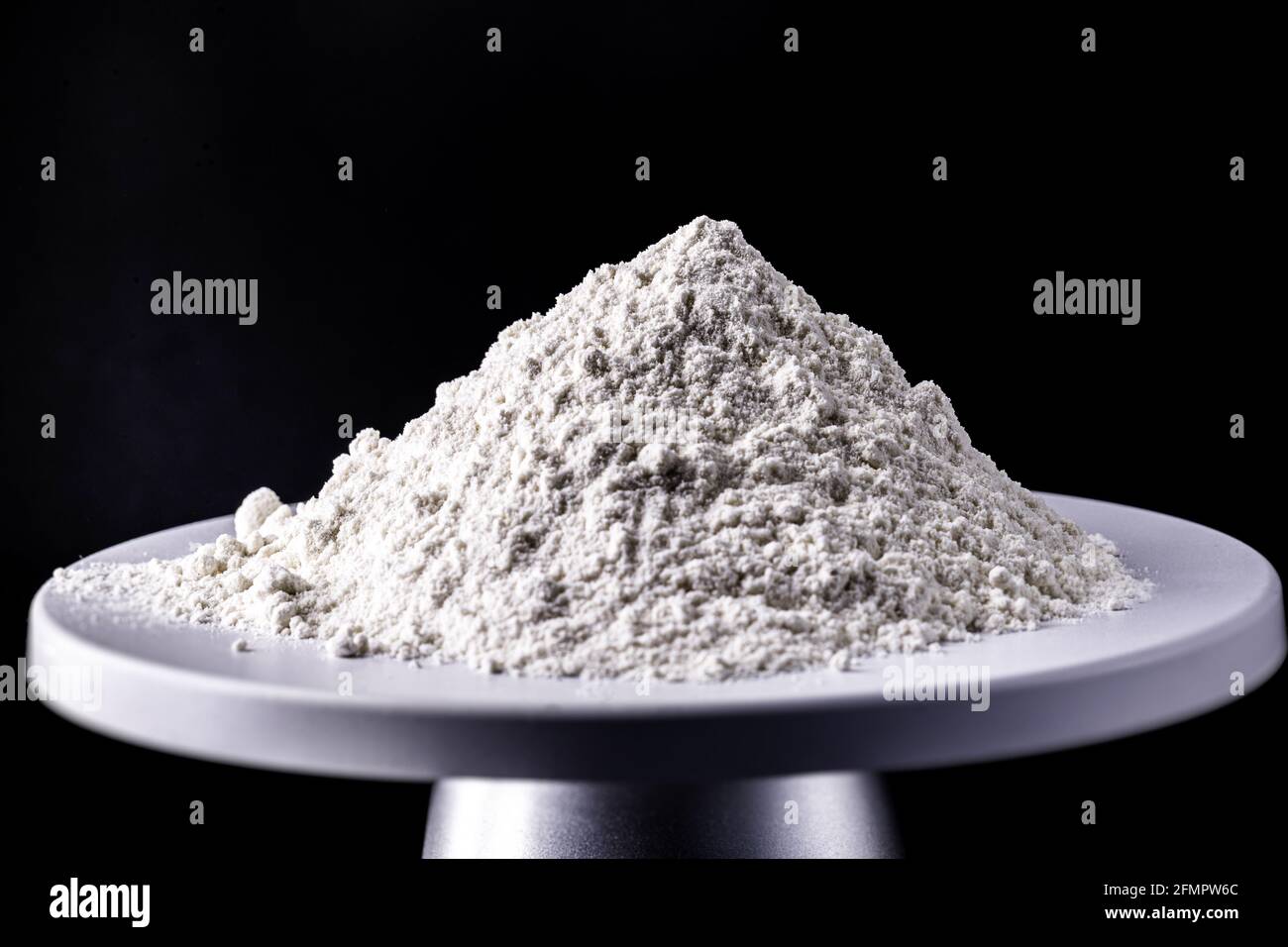 kaolin, on a weighing scale, kaolin is a mineral of inorganic constitution Stock Photo