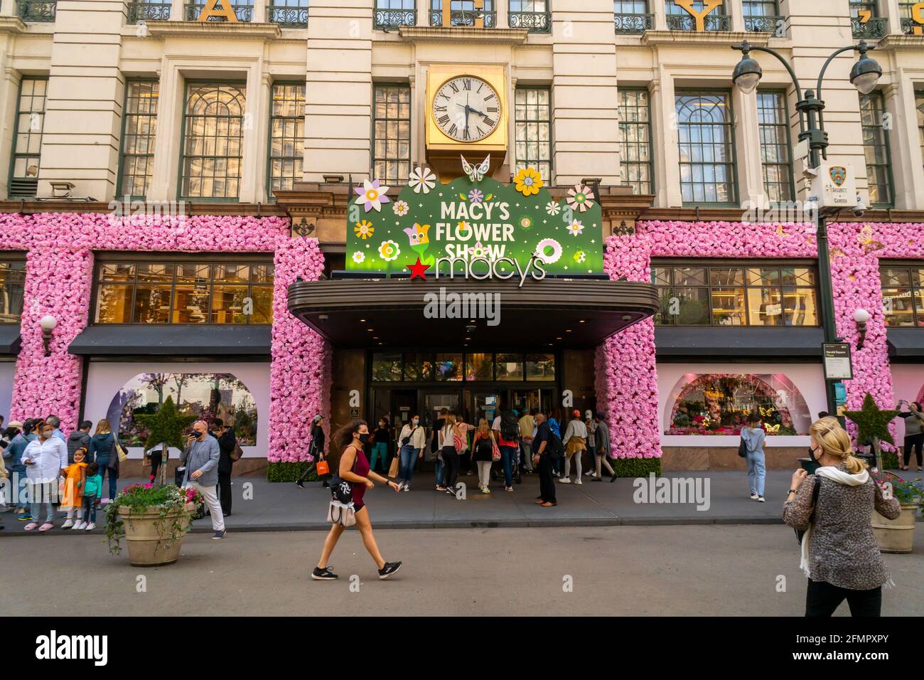 Visitors outside Macy's flagship department store in Herald Square in New  York which is festooned with floral arrangements for the annual Macy's  Flower Show, on opening day Sunday, April 2, 2021. Visitors