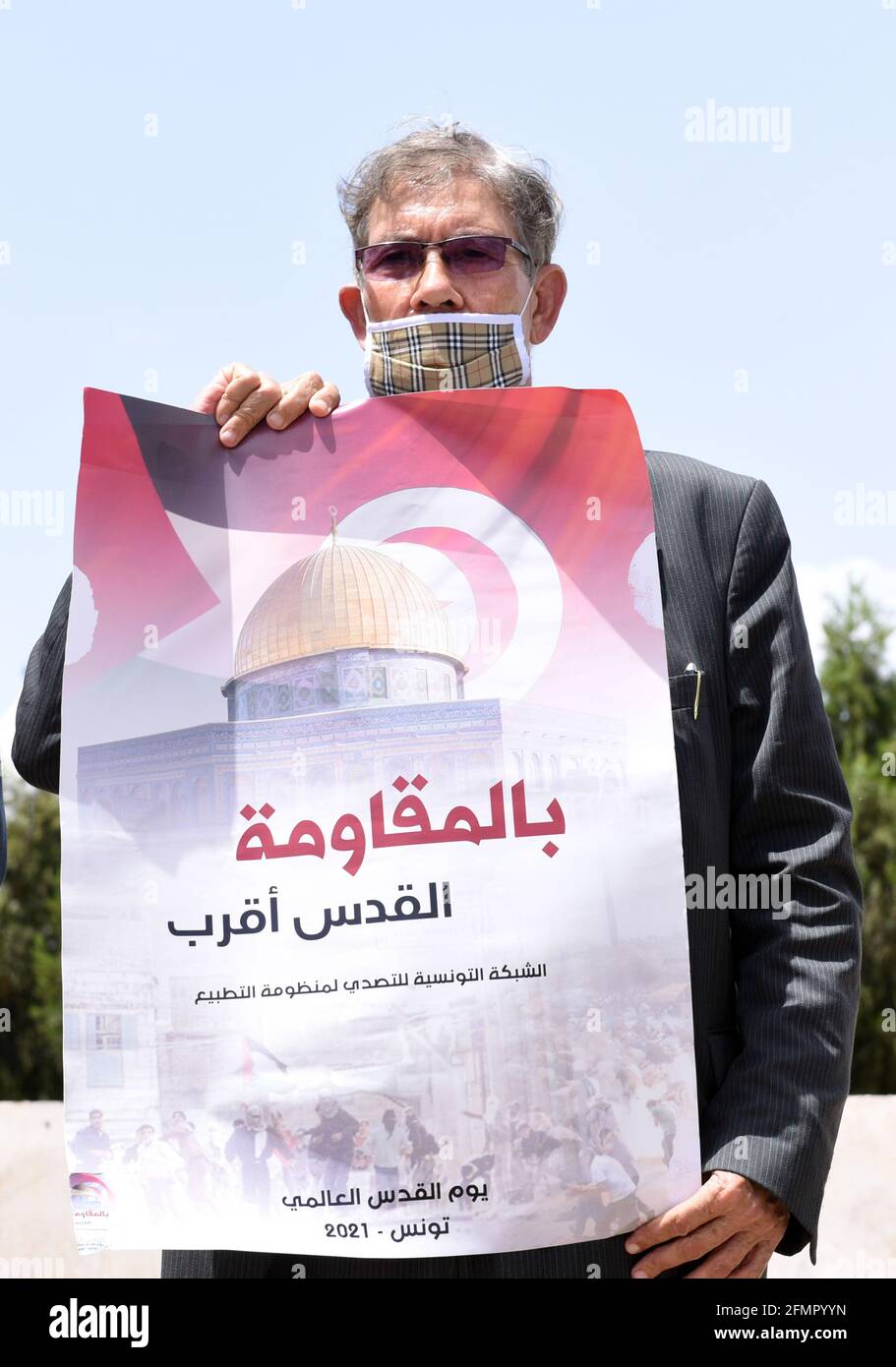 Tunis, Tunisia. 10th May, 2020. A protester wearing a face masks holds a placard during a demonstration.Protesters gathered in the capital Tunisia to protest against the entry of Israeli security forces into Masjid al-Aqsa, which is considered a sacred place for Muslims. Credit: Jdidi Wassim/SOPA Images/ZUMA Wire/Alamy Live News Stock Photo