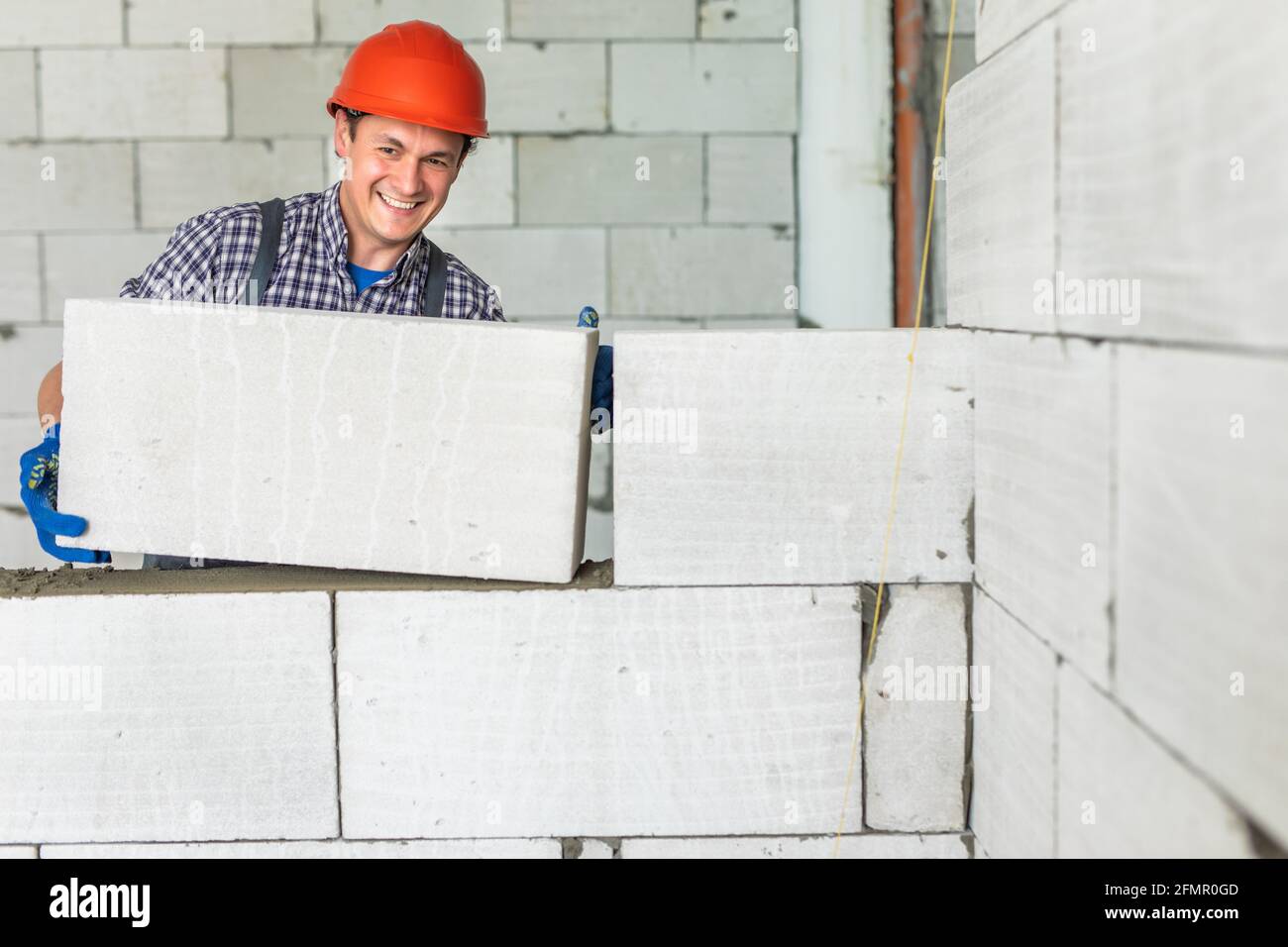 bricklayer builder working with autoclaved aerated concrete blocks
