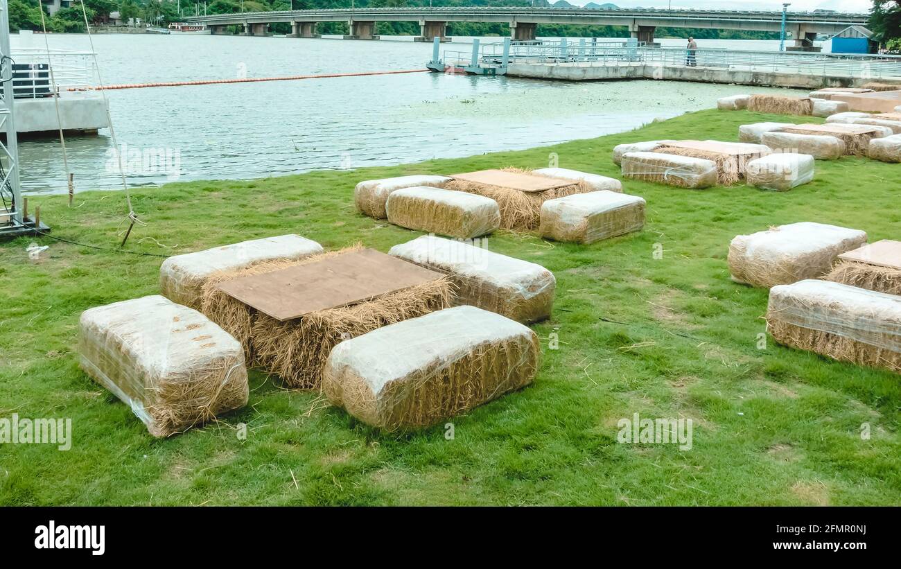 Seats and tables made from straw bales for event and party laid on lawn