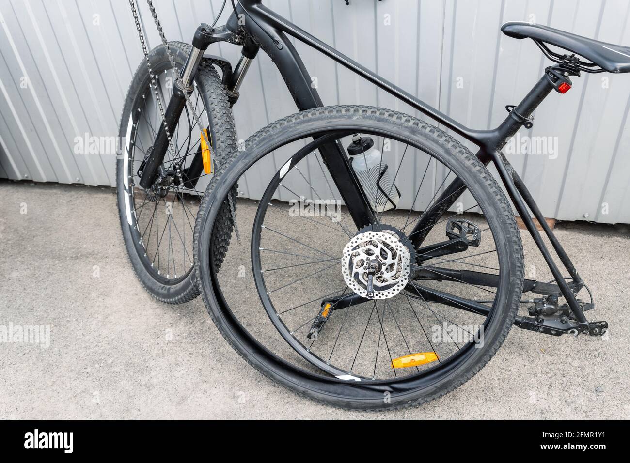 Disassembled black carbon fiber bicycle with removed wheel and tyre