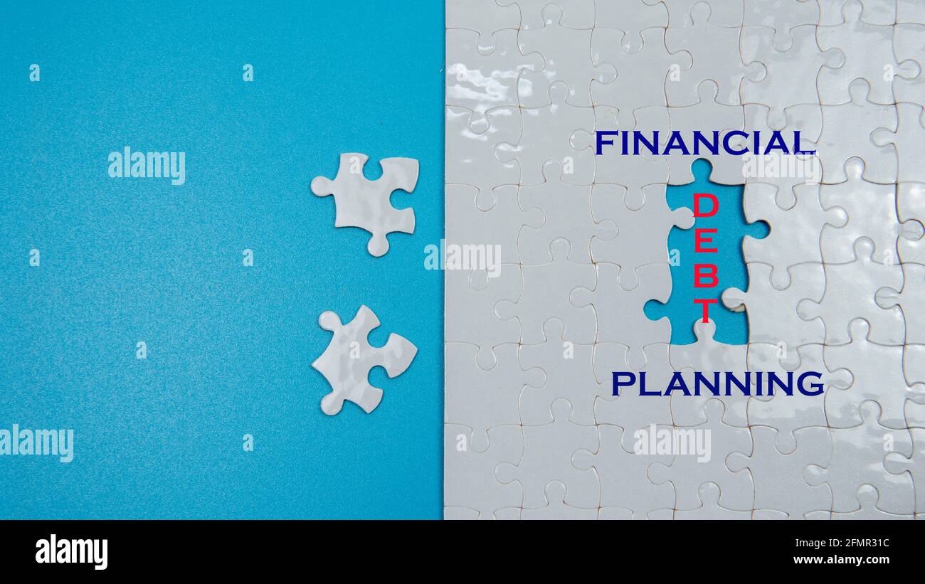 Selective focus of management concept with piece of jigsaw puzzle with financial, planning and debt wording Stock Photo
