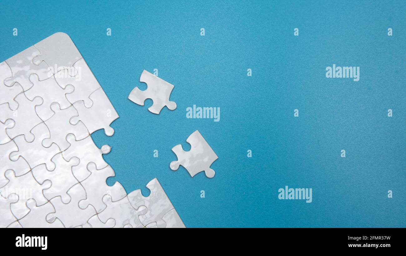 Selective focus of piece of jigsaw puzzle with a blue background Stock Photo