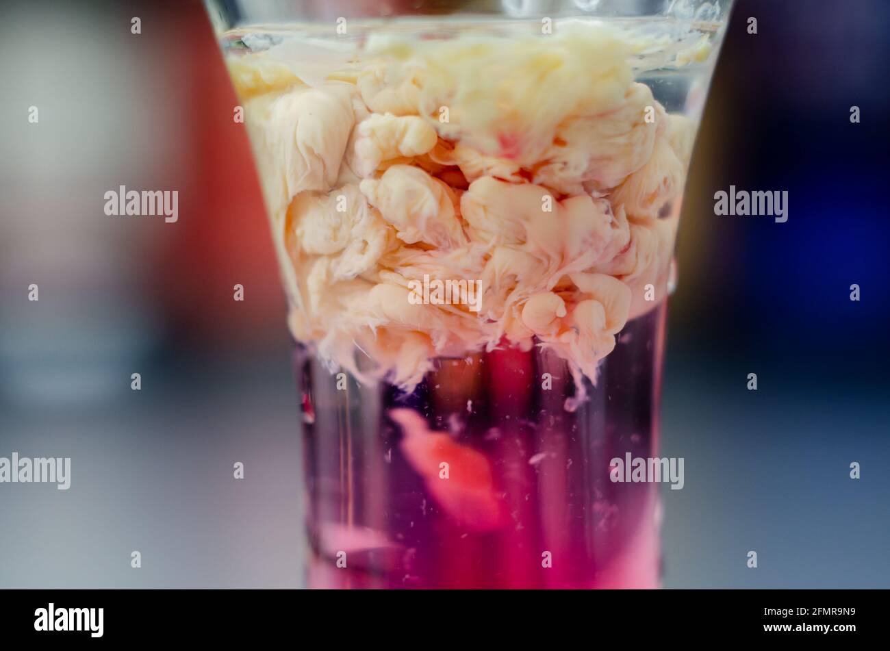 Interesting drink shot based on cream, liqueur and grenadine called Brain Hemorrhage prepared for Halloween party, scary drink Stock Photo