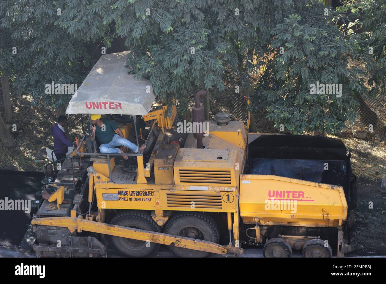 Mumbai, Maharashtra, India, January 08 2021: Yellow road roller on the job, preparing the metalled road Stock Photo
