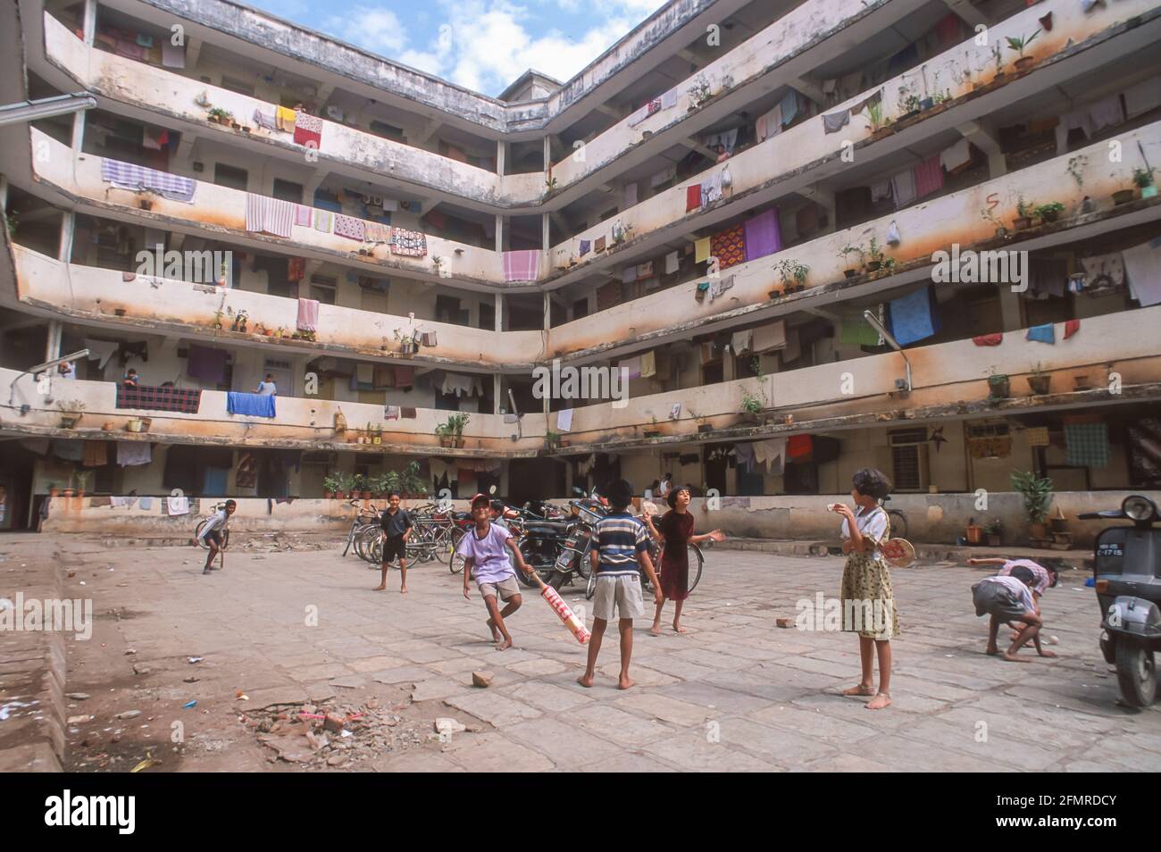 MUMBAI, INDIA - Children play cricket in courtyard of housing for city police families. Stock Photo