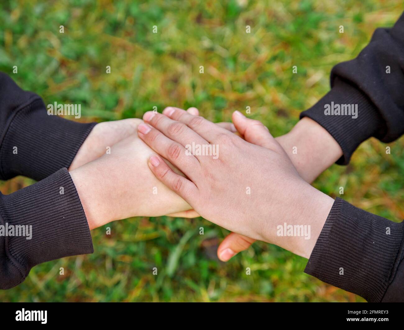 Children's hands clasped together as sign of friendship. Stock Photo