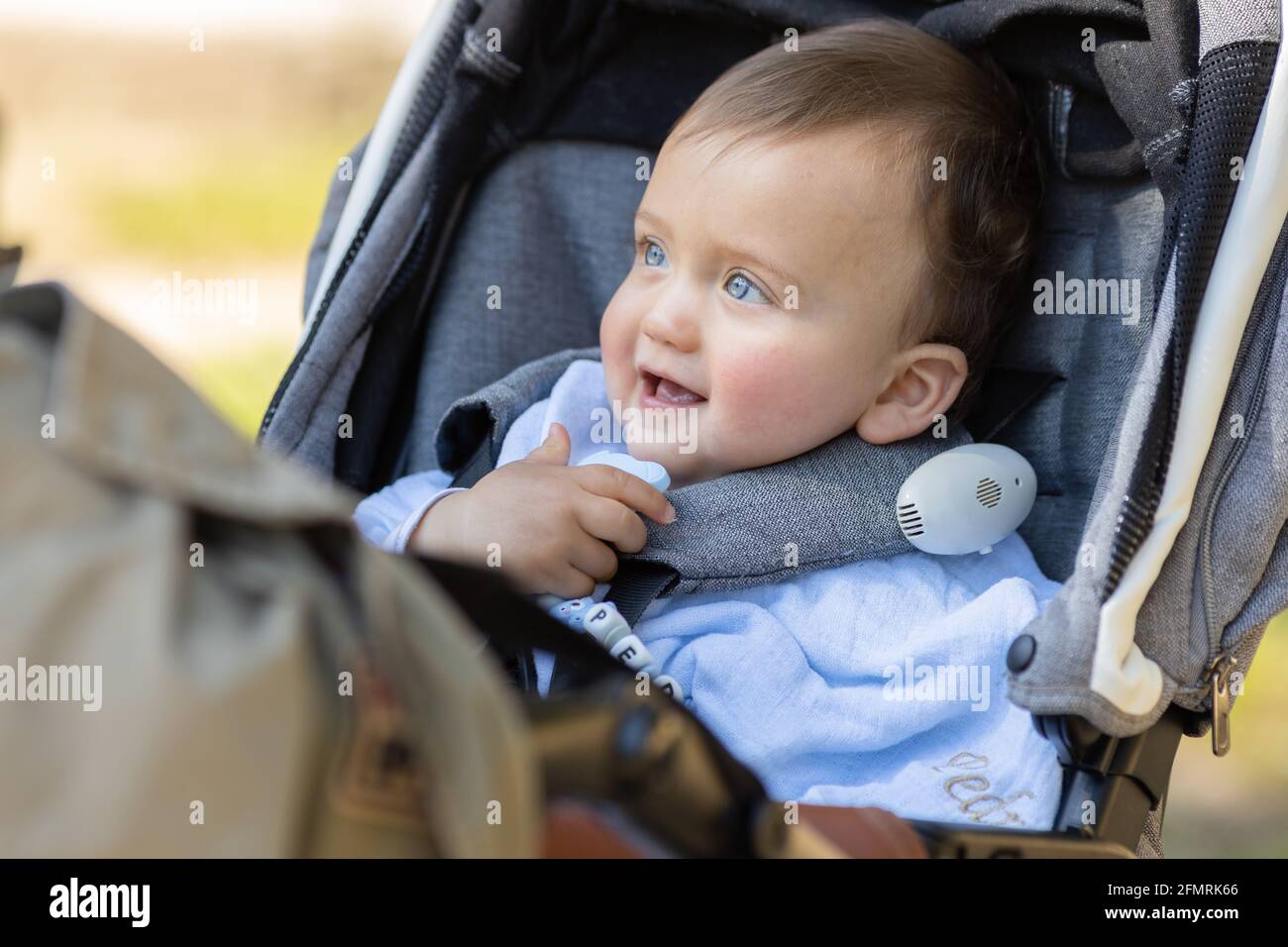 Baby boy smiling and seated in his pram Stock Photo Alamy