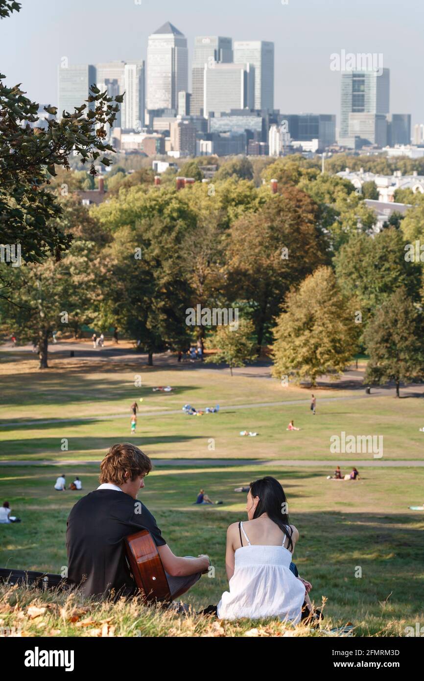 LONDON, UK - October 03, 2011. Young Caucasian couple with a guitar sitting in Greenwich Park, central London Stock Photo