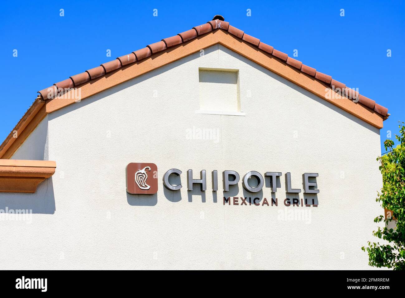 Chipotle Mexican Grill sign and logo above the entrance to chain restaurant location - San Jose California, USA - 2021 Stock Photo
