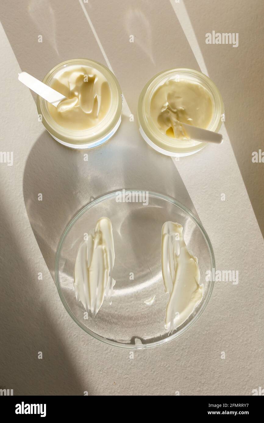 Cosmetic cream container with face or body cream on neutral background