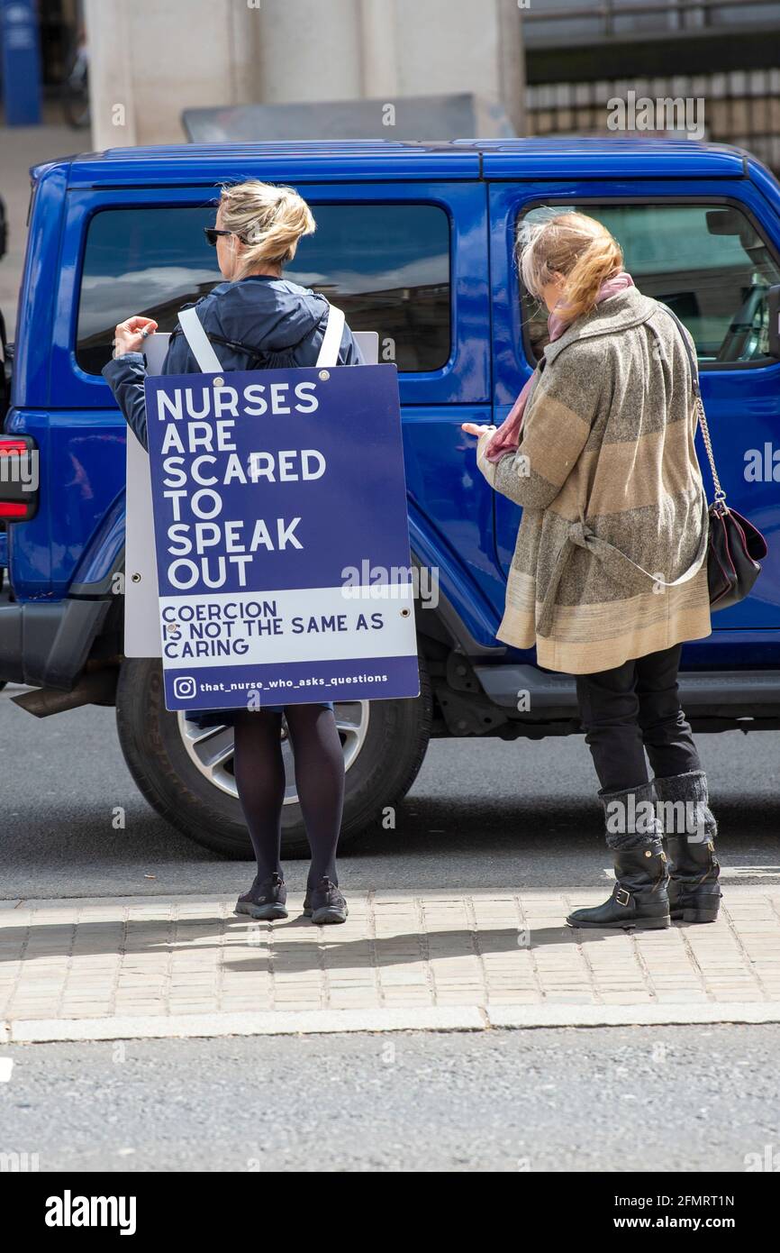 London, UK. 11th May, 2021. A woman is seen next to Jenna Platt, Registered General Nurse (RGN), Registered Mental Nurses (RMN). 'The Nurse Who Asks Questions' demonstrates in London while wearing a sandwich board.Jenna runs the lockdownalternative.com website supporting individuals who have been negatively impacted by lockdown but do not feel heard or supported and health and social care professionals who have reached out to share their stories of being fearful of or being ostracized due to human rights, employment law, whistleblowing etc. Credit: SOPA Images Limited/Alamy Live News Stock Photo