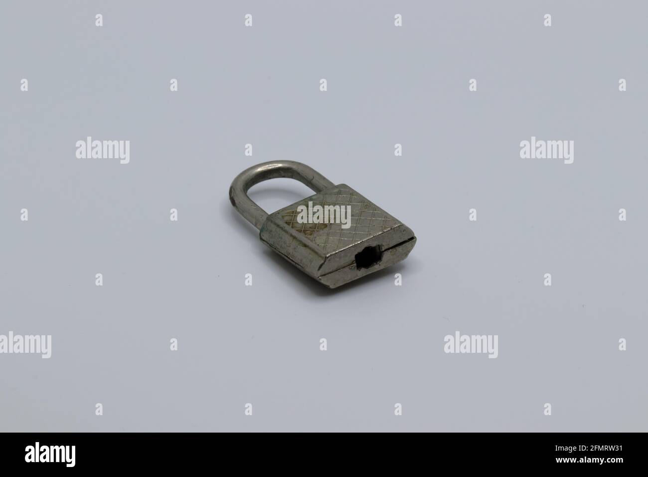 An old padlock that has slightly rusted against a white background Stock Photo