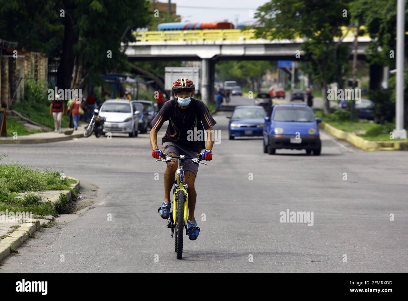 Valencia, Carabobo, Venezuela. 11th May, 2021. May 11, 2021. A man, wearing a face mask, rides a bicycle in the entrance area of Naguanagua, Carabobo state. Photo: Juan Carlos Hernandez Credit: Juan Carlos Hernandez/ZUMA Wire/Alamy Live News Stock Photo