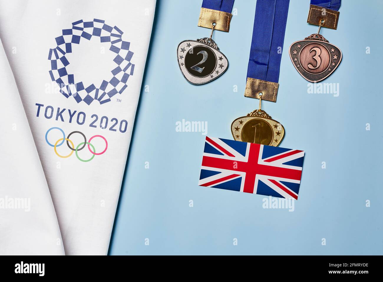 Tashkent, Uzbekistan - March 4, 2021: 2020 Summer Olympic Games logo on white towel and Golden, Silver and Bronze olympic medals Stock Photo