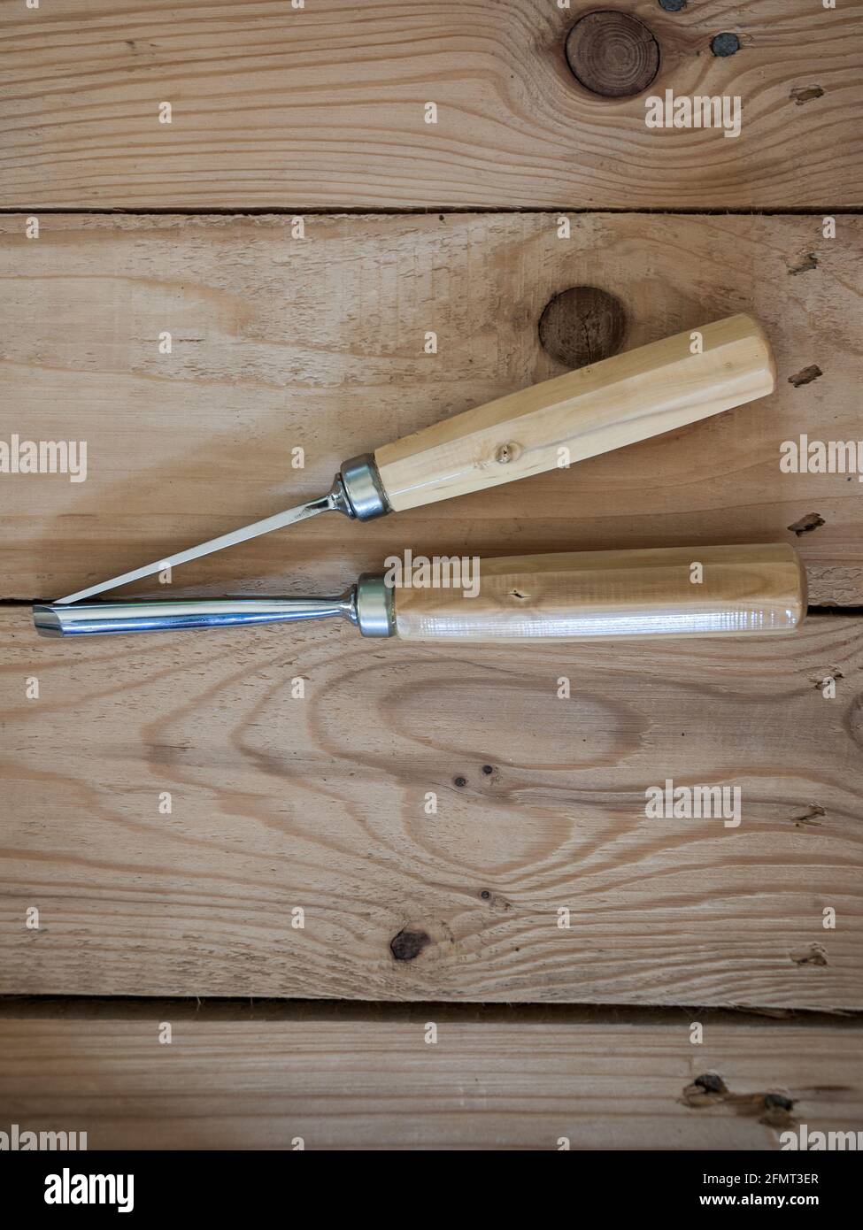 Vertical shot of two gouges with wooden handles on a table Stock Photo ...