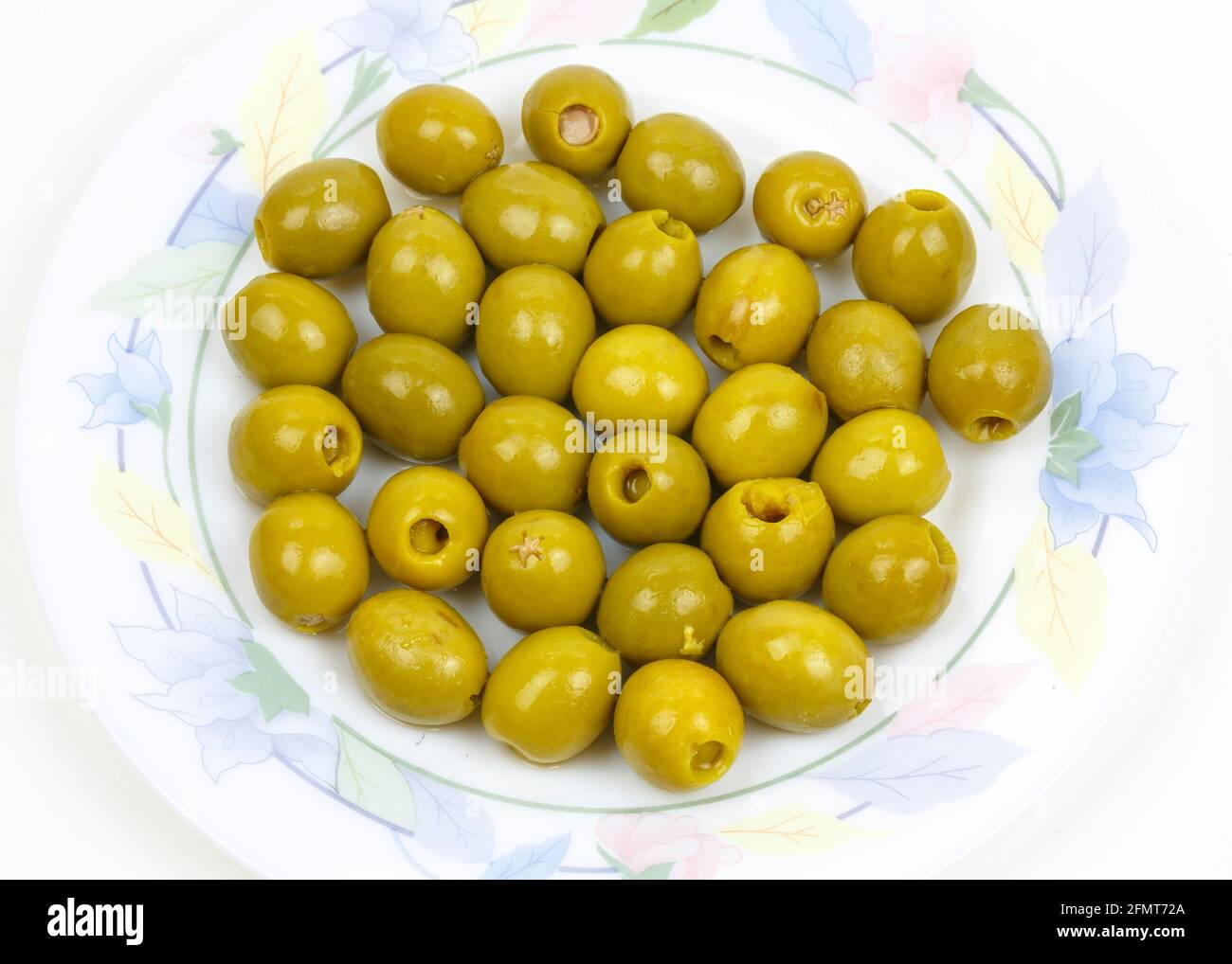 a plate with olives with toothpicks served as tapas on a white background Stock Photo